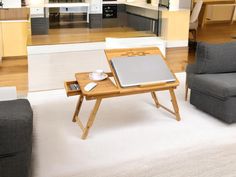 a living room filled with furniture and a laptop computer on top of a wooden table