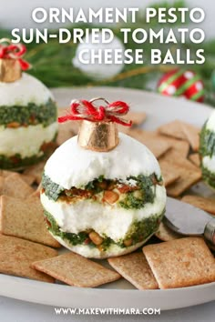 an ornament pesto sun - dried tomato cheese balls on a plate with crackers