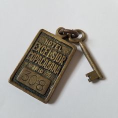 an old key is attached to a metal tag that says hotel excelesior dupagrania