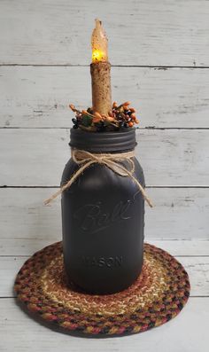 a mason jar with a lit candle in it