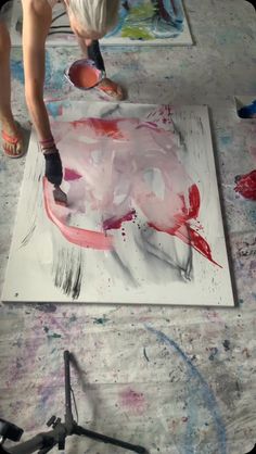 a person is painting on a large piece of paper