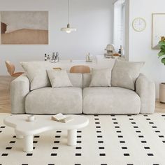 a living room with a white couch and black and white checkered rug on the floor