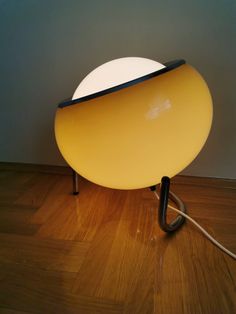 a yellow lamp sitting on top of a wooden floor