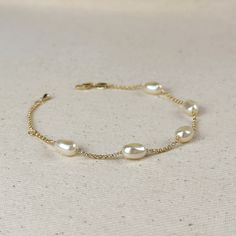 Indulge in the timeless beauty and sophistication of our 18k Gold Filled Spaced Baroque Pearl Bracelet. The perfect blend of elegance and delicacy, this classic piece exudes a luxurious charm that will elevate any outfit. Add a touch of opulence to your wardrobe and captivate with every turn of your wrist. * Metal: 18k Gold Filled * Width: 10mm Simulated Baroque Pearl  Beads * Size:  6.5 + 1 inch adjustment. * Hypoallergenic * Water-resistant * Handcrafted in Brazil Formal White Gold Bracelets With Pearl Chain, Elegant Pearl Chain Bracelets For Wedding, Elegant Pearl Chain Bracelet For Anniversary, Elegant Gold Adjustable Bracelet For Formal Occasions, Formal Pearl Chain Bangle Bracelet, Elegant Adjustable Gold Bracelet For Formal Occasions, Elegant Wedding Bracelets With Pearl Chain, Elegant Pearl Drop Bracelet For Party, Elegant Pearl Bracelet For Party