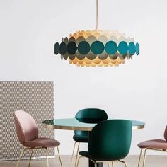 a dining room table with chairs and a chandelier hanging from it's ceiling