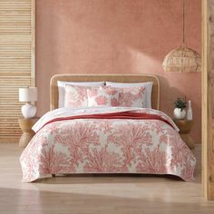 a bed in a bedroom with pink walls