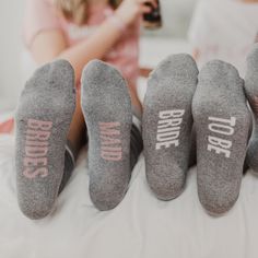 three pairs of socks with the words bride and groom printed on them sitting on a bed