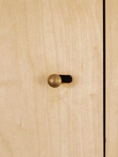 a close up of a wooden cabinet with a black handle