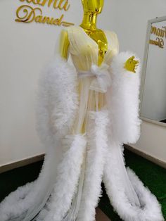 a mannequin dressed in white and yellow feathers