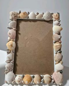 a frame made out of seashells on a table