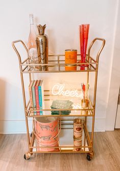 a gold bar cart with drinks on it