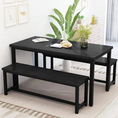 a black table with two benches next to it and a potted plant on top