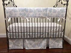 a metal crib with blue and white bedding