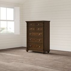 an empty room with white walls and wood flooring on the floor, there is a chest of drawers in the corner