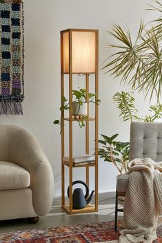 a living room with a chair, lamp and potted plant