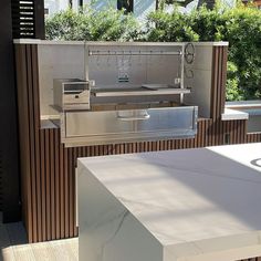 an outdoor bbq grill on a deck with trees in the background