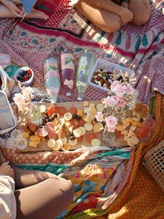 a woman laying on top of a blanket covered in lots of food and condiments