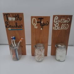 three mason jars with toothbrushes and toothpaste in them