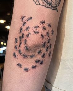 a person with a tattoo on his arm has many bugs all over him and is looking at the camera