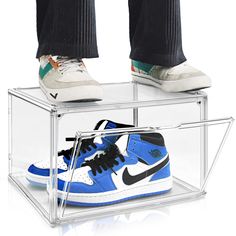 a pair of shoes that are sitting in a glass box on top of each other