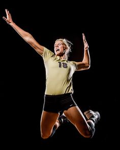 a woman jumping in the air with her arms outstretched