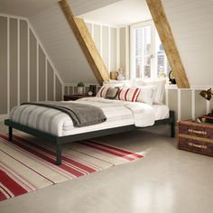 an attic bedroom with slanted ceilings and striped rugs on the floor, along with a bed