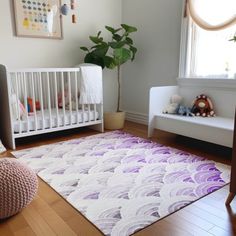 a baby's room with a white crib and purple rug