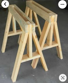 three wooden stools sitting next to each other on top of cement flooring area