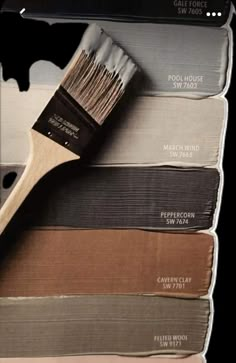 a paint brush sitting on top of different shades of paint