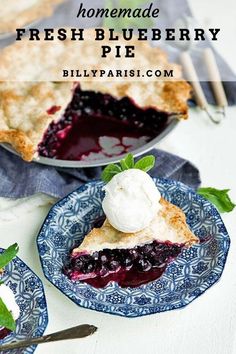 homemade fresh blueberry pie on two plates with ice cream and mint garnish