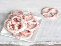 two white plates with red sprinkles on them and one plate is filled with pretzels