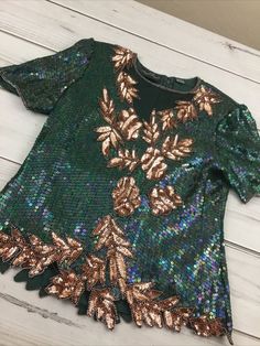 Women's Razzle Dazzle Green/Gold Sequin & Silk Short Sleeve Blouse *No size tag*. See measurements photos. Item is in used condition. Shipped with USPS Shipping. Festive Green Sequined Tops, Festive Green Sequin Tops, Green Sequin Tops For Fall, Green Sequined Party Blouse, Green Sequined Blouse For Evening, Green Sequined Short Sleeve Tops, Fall Sequined Short Sleeve Blouse, Fall Sequin Short Sleeve Blouse, Vintage Green Blouse For Party