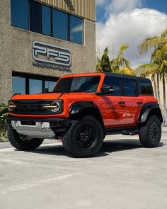 an orange truck parked in front of a building