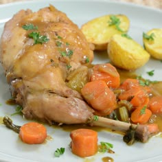 a white plate topped with chicken, potatoes and carrots