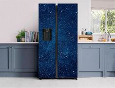 a large blue refrigerator in a kitchen next to a counter top oven and cabinets with books on it