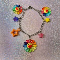 a multicolored bracelet with charms on it and stars around the clasps is shown