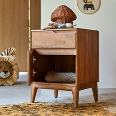 a small wooden cabinet sitting on top of a rug next to a stuffed animal toy