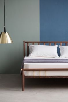 a bed with white pillows and blue walls