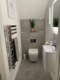 a white toilet sitting in a bathroom next to a sink