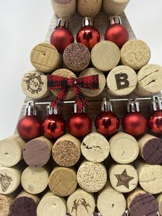 a christmas tree made out of wine corks with ornaments on the top and bottom