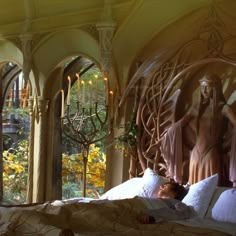 a woman laying in bed next to an archway