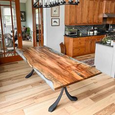 a wooden table sitting in the middle of a kitchen