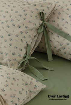 two pillows with bows tied around them on a bed