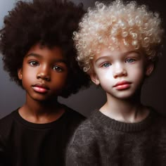 two young children with curly hair posing for the camera in front of a dark background