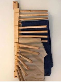 clothes hanging on the wall with wooden pegs attached to it's back pocket