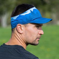 This lightweight visor is designed for atheletes and outdoor enthusiast. Our performance visor features a wide brim and stretchable band for all-day comfort. The breathable and moisture-wicking material keeps you dry and cool during any activity. These foldable visors are also reversible, offering two unique designs in one! The design on one side features mountains and trees and solid blue on the other. Keep the sun, hair, and sweat off your face while showing off your outdoorsy nature in our co Breathable Outdoor Visor, One Size Fits Most, Brimmed Outdoor Visor With Upf 50+, Lightweight Sports Visor, One Size Fits Most, White Outdoor Visor With Upf 50+, Adjustable Upf 50+ Curved Visor, Wide Brimmed, Moisture Wicking, Unique Designs, Running