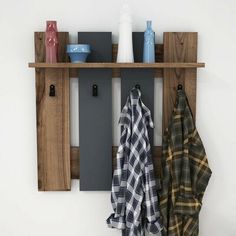 a coat rack with two coats hanging from it's sides and three towels on the hooks