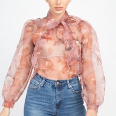 Semi Sheer Floral Organza Tunic Blouse With Tie Neck. Long Balloon Sleeves. 100% Polyester. Pink Sheer Long Sleeve Top, Chic Floral Print Tops For Party, Feminine Spring Blouse, Elegant Pink Top For Spring, Summer Sheer Pink Blouse, Sheer Pink Blouse For Summer, Chic Peach Top For Fall, Spring Sheer Pink Blouse, Pink Sheer Blouse For Spring