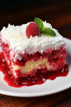 a piece of cake with whipped cream and raspberry topping on a white plate