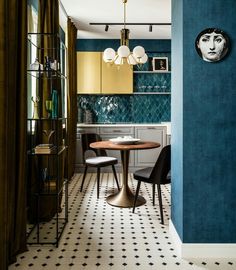 a dining room table and chairs in front of a blue wall